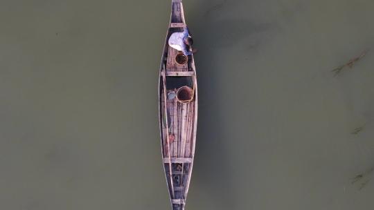 漂浮在伊查马蒂河上的传统木船上孤独渔夫的鸟瞰图。Sl