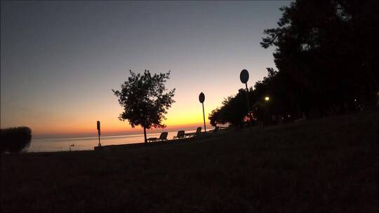 人们在日落时在海滩上散步 延时