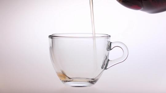将泡好的茶水倒入透明茶杯
