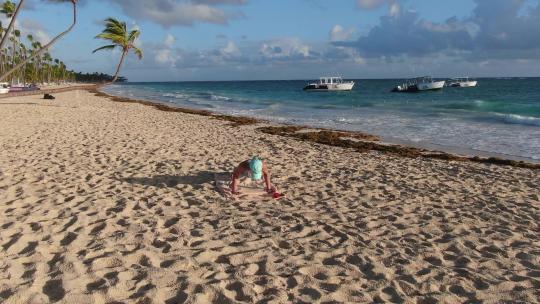 多米尼加共和国度假年轻女子在海滩上锻炼俯卧撑