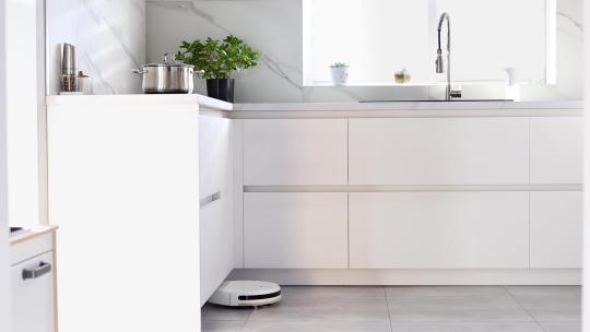 自动吸尘器正在清洁厨房的地板视频素材模板下载