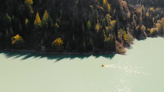 一个人在山湖的筏子上划船