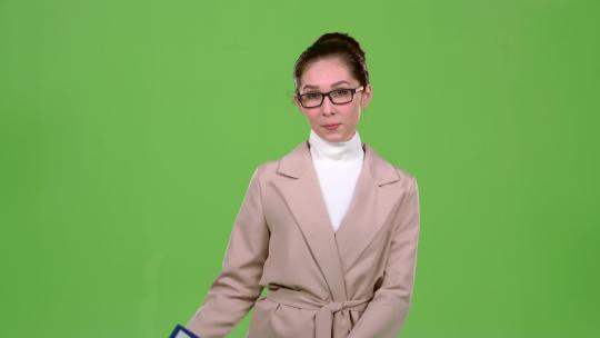 女孩广告代理在平板电脑上显示重要信息。绿屏。慢动作