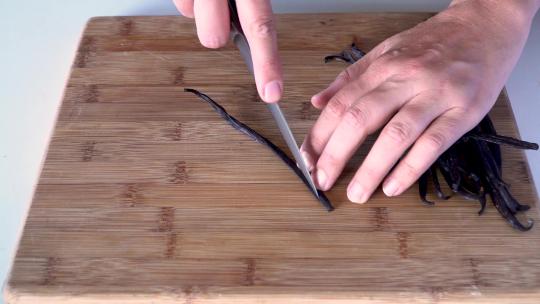 双手用刀切开新鲜香草豆荚视频素材模板下载