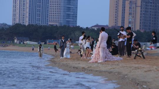 威海西海岸沙滩上拍婚纱照的人群