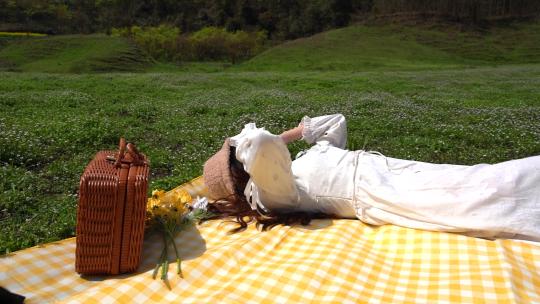 户外休闲少女野餐垫上晒太阳实拍视频