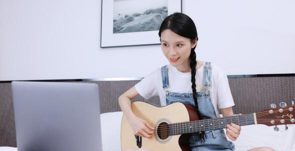 女生在家里学习弹吉他