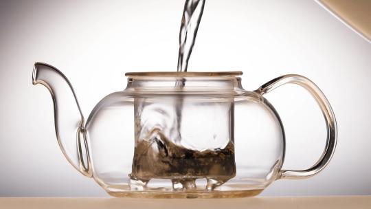 特写用开水冲泡透明茶壶中的茶叶