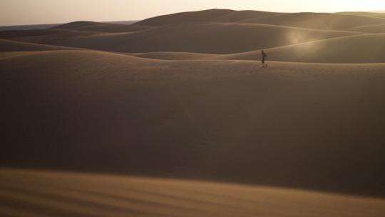 在沙漠里行走的男人视频素材模板下载