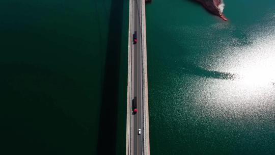 波光粼粼湖面上的百米跨河大桥车辆行驶