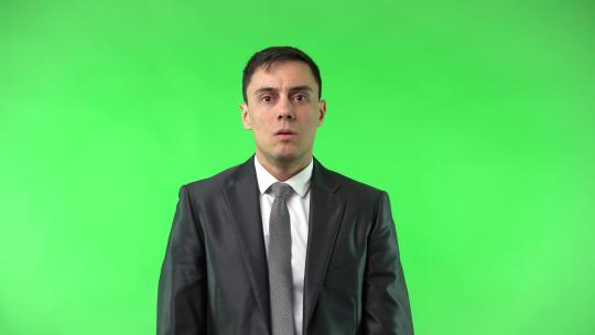 绿色背景前一名男性做张嘴吃惊的表情视频素材模板下载