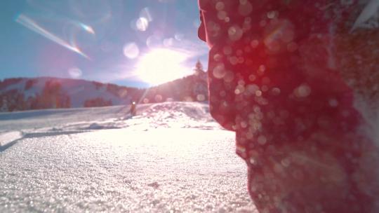 日光下低角度拍摄在雪地上奔跑的人