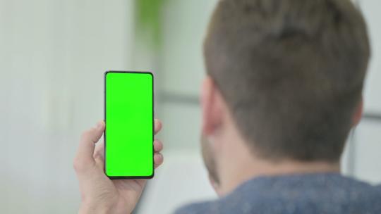 使用绿屏智能手机的成熟成年男子