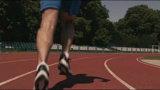 低角度拍摄在塑胶跑道上跑步的人