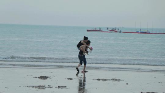 背着情侣在海边沙滩散步