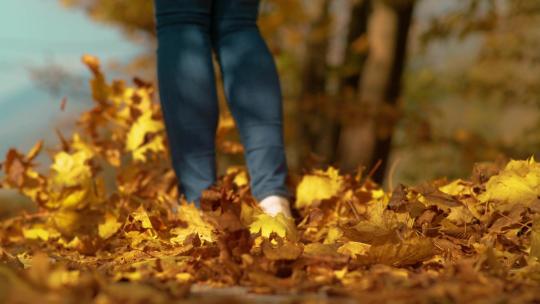 美女行走在秋天的落叶路上慢动作