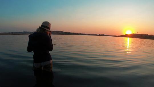 日落时女孩钓鱼