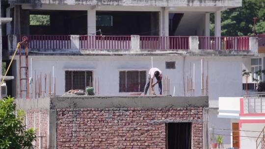 男子在楼顶砌水泥