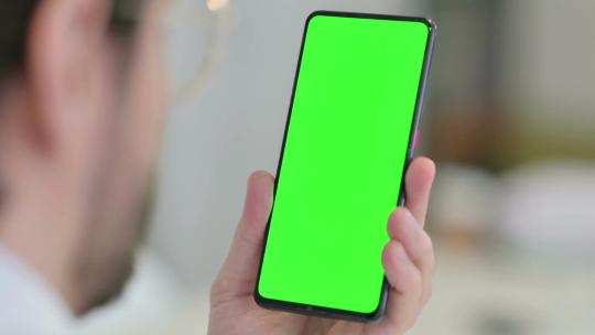 男性使用带有绿色屏幕的智能手机