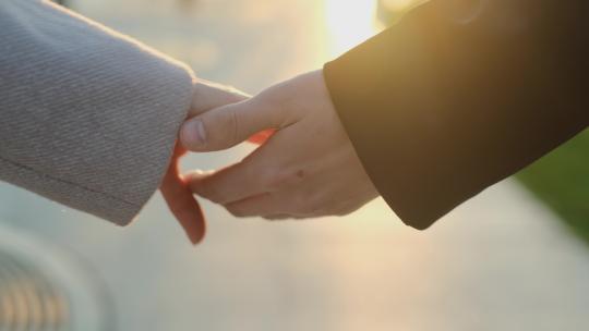 年轻夫妇手牵着手在公园散步
