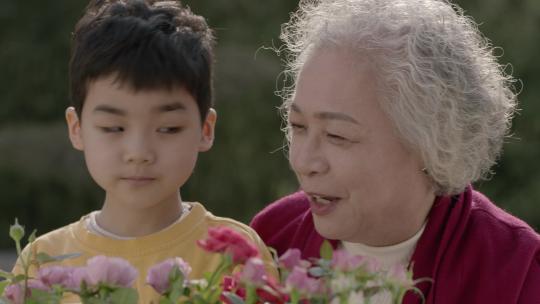 老年幸福生活奶奶陪伴孙子玩气色好庭院浇花