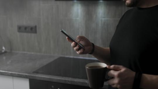 男人拿着咖啡玩手机视频素材模板下载