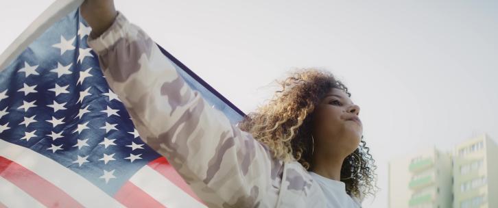 城市里举着美国国旗的年轻女子的视频