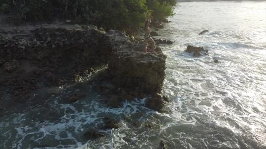 日落时站在巴西海洋边缘岩石上的女孩。平静的波浪。
若昂佩索阿，巴西By