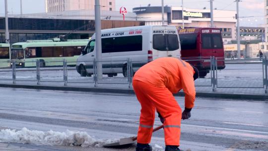 冬天清洁工人清理路边积雪