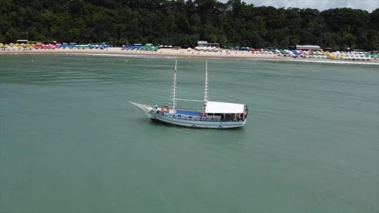 航拍美丽的海滨船沿着海岸在蓝色温暖的水域