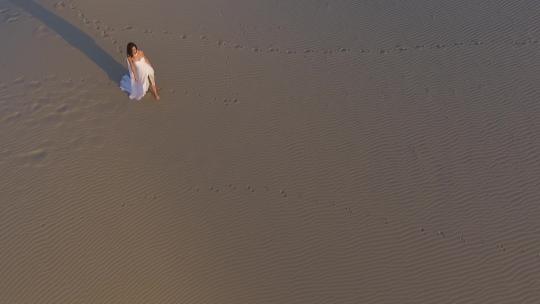 白裙女人走在沙丘上