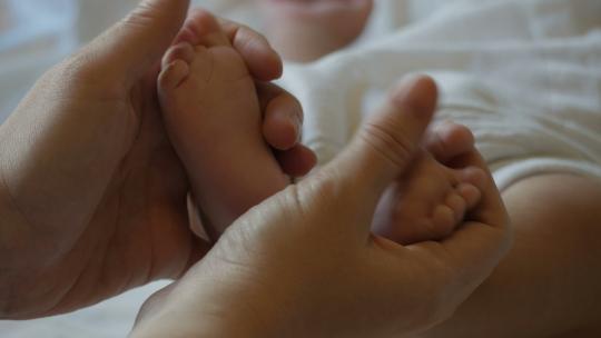 手轻轻抚摸婴儿的小脚视频素材模板下载