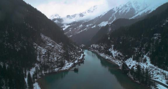 大雪期间阿尔卑斯山蓝色水的山湖，背景是山脉