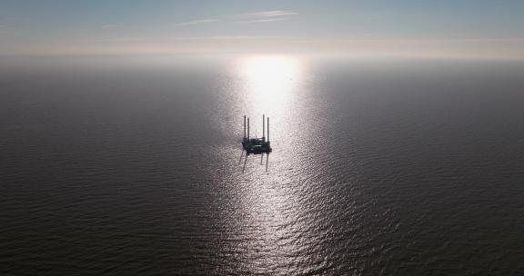航拍波光粼粼的海面与石油钻井平台