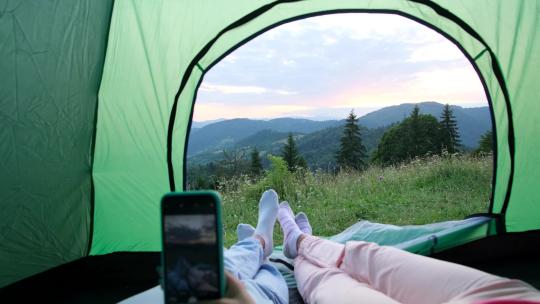 两人在帐篷里玩手机