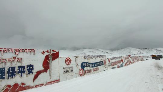西藏旅游317国道车窗外冰雪路面藏文标语墙