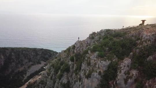 一人个人站在岩石上看落日