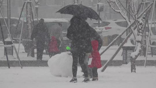大雪中亲子家庭玩雪打雪仗