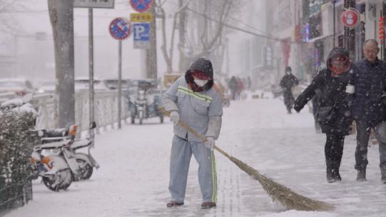 风雪中环卫工人打扫街道