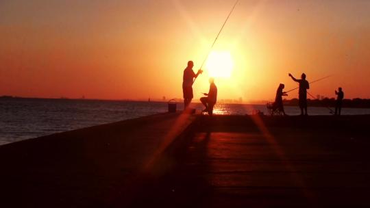 人们在夕阳下钓鱼