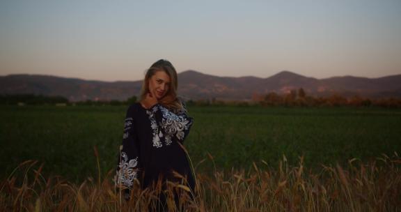 一个穿着刺绣衬衫和乌克兰vyshyvanka的浪漫乡村女孩站在麦田里