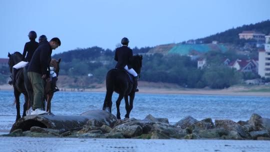 威海日落湾沙滩上策马奔腾的骑手