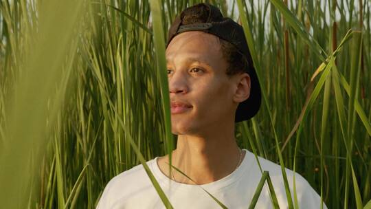 一个年轻人以高大的野草为背景拍照
