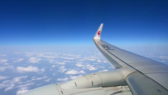 飞机飞行在云层之上透过舷窗俯瞰祖国大地