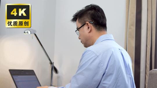 男子居家办公使用笔记本电脑打字工作