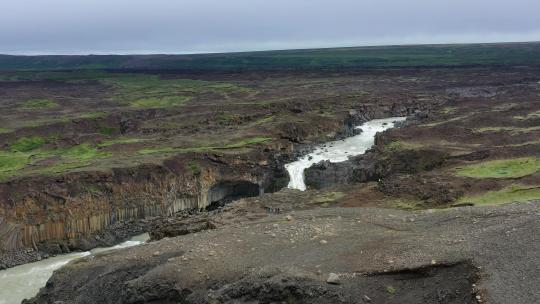 冰岛。从无人机上观看峡谷中的河流和瀑布。冰岛白天的风景。