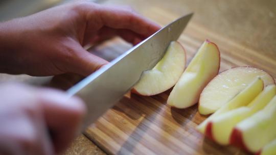 慢镜头拍摄一个人用刀把苹果切成小块视频素材模板下载