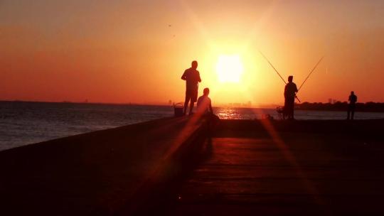 人们在夕阳下钓鱼