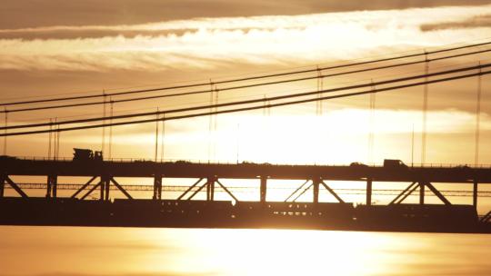 夕阳下悬索桥行驶的列车