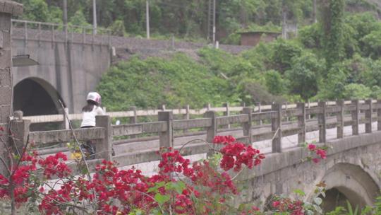 女子骑着MINI摩托车过桥